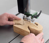 Wooden puzzle piece being cut by a band saw with hands guiding it using the Cobra Scroll guide system for Sabre bandsaws - Record Power